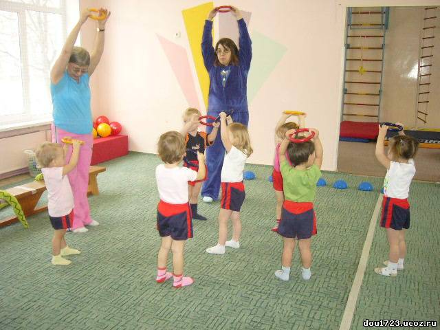 Физкультурное в первой младшей группе. Физкультурные занятия в детском саду. Занятие по физкультуре в младшей группе. Физические упражнения в младшей группе. Воспитатель на физкультуре.